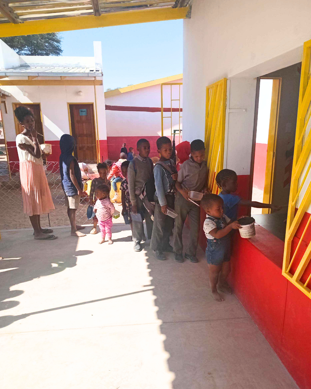 Children collect a hot meal from the soup kitchen at the Otto Xamseb Education Centre in Rehoboth, Namibia.