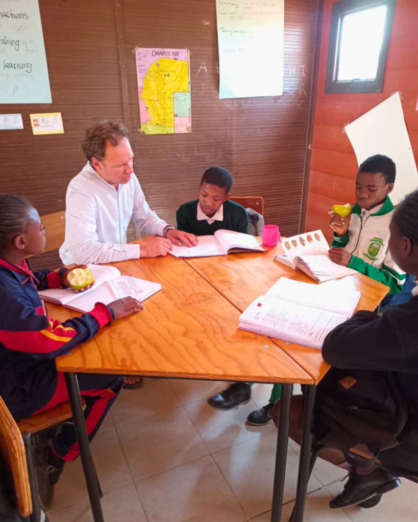 Participants in a social holiday accompany children while learning in an Education Center of steps for children in Namibia.